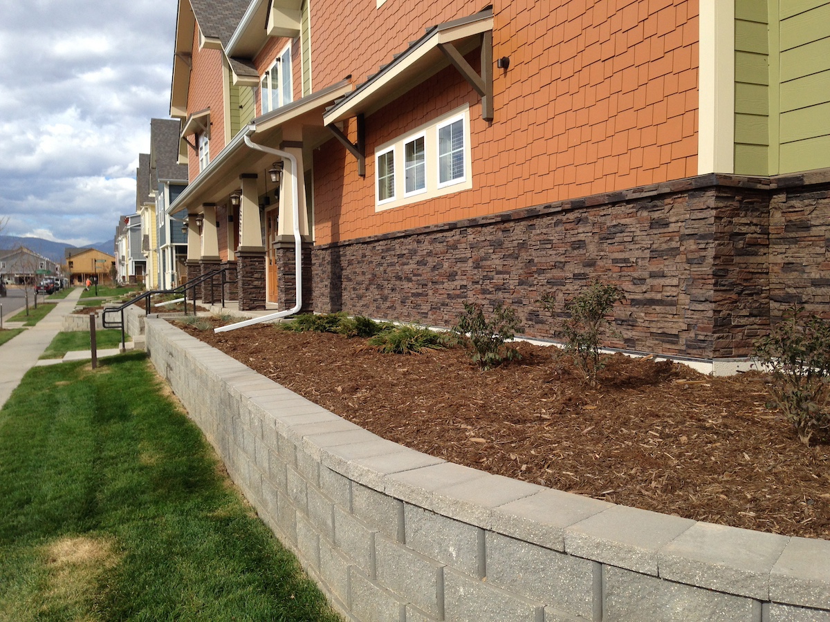 An apartment building attractively decorated with Sierra Brown Colorado Dry Stack Faux Stone Wall Panel Siding 