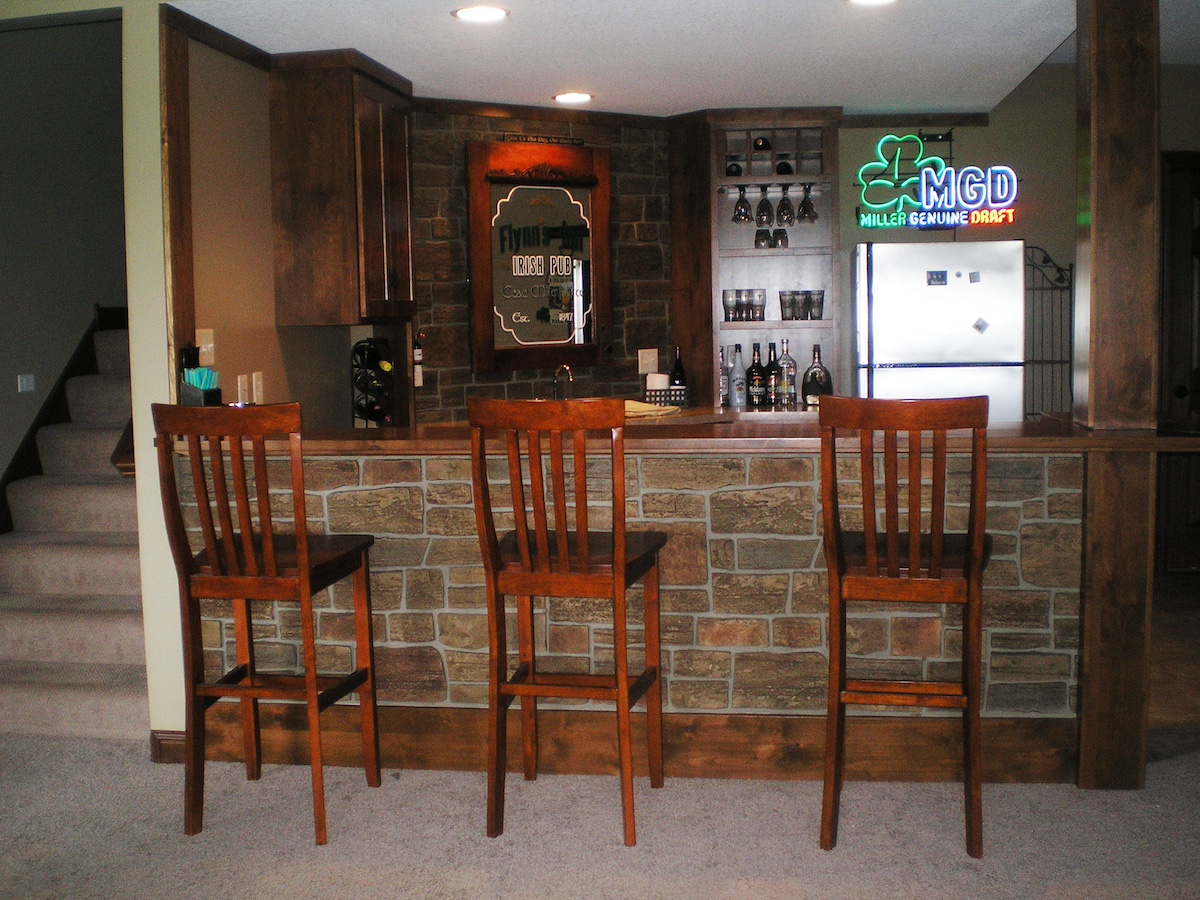 Harvest color Lehigh Cobblestone Faux Stone Wall Panels being used to create a unique basement bar look